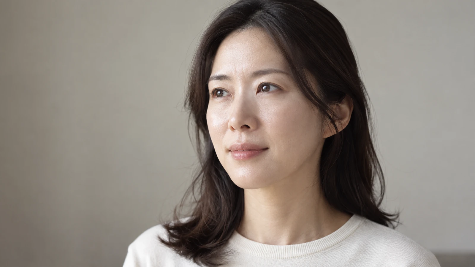 양쪽 눈과 자연스러운 눈밑 피부결이 보이는 성인 여성의 사선 얼굴